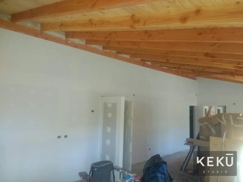 Interior de vivienda con revestimientos claros y cubierta de madera